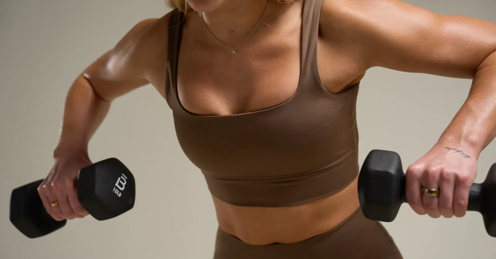 woman hinging forward rowing her arms back with weights