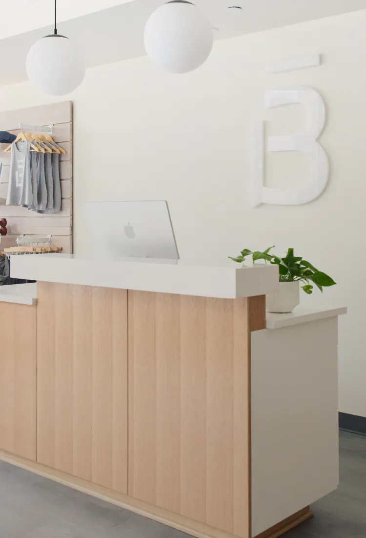 front desk of a barre3 studio with a B logo on the back wall