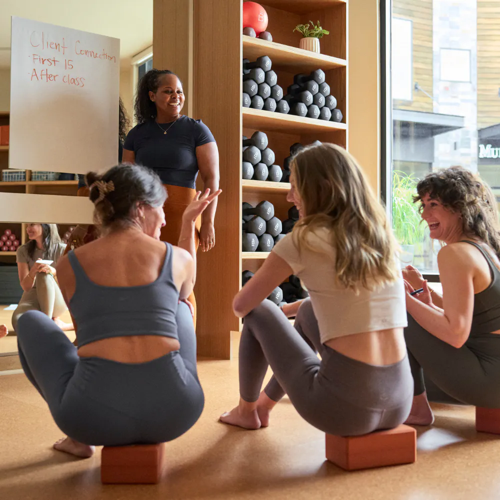 woman fitness instructor teaching a group of instructors at a whiteboard