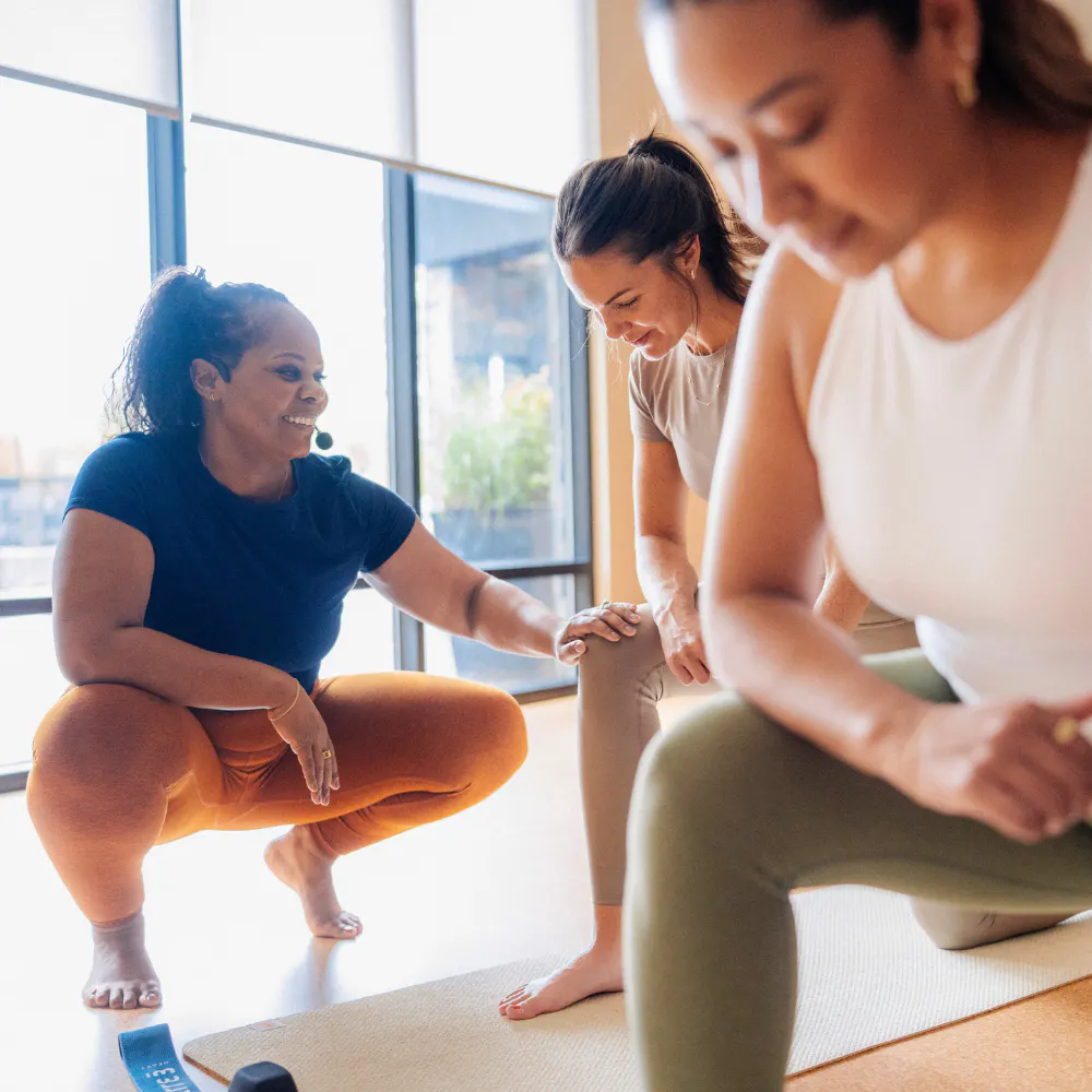 woman fitness instructor checking in with one of class participants