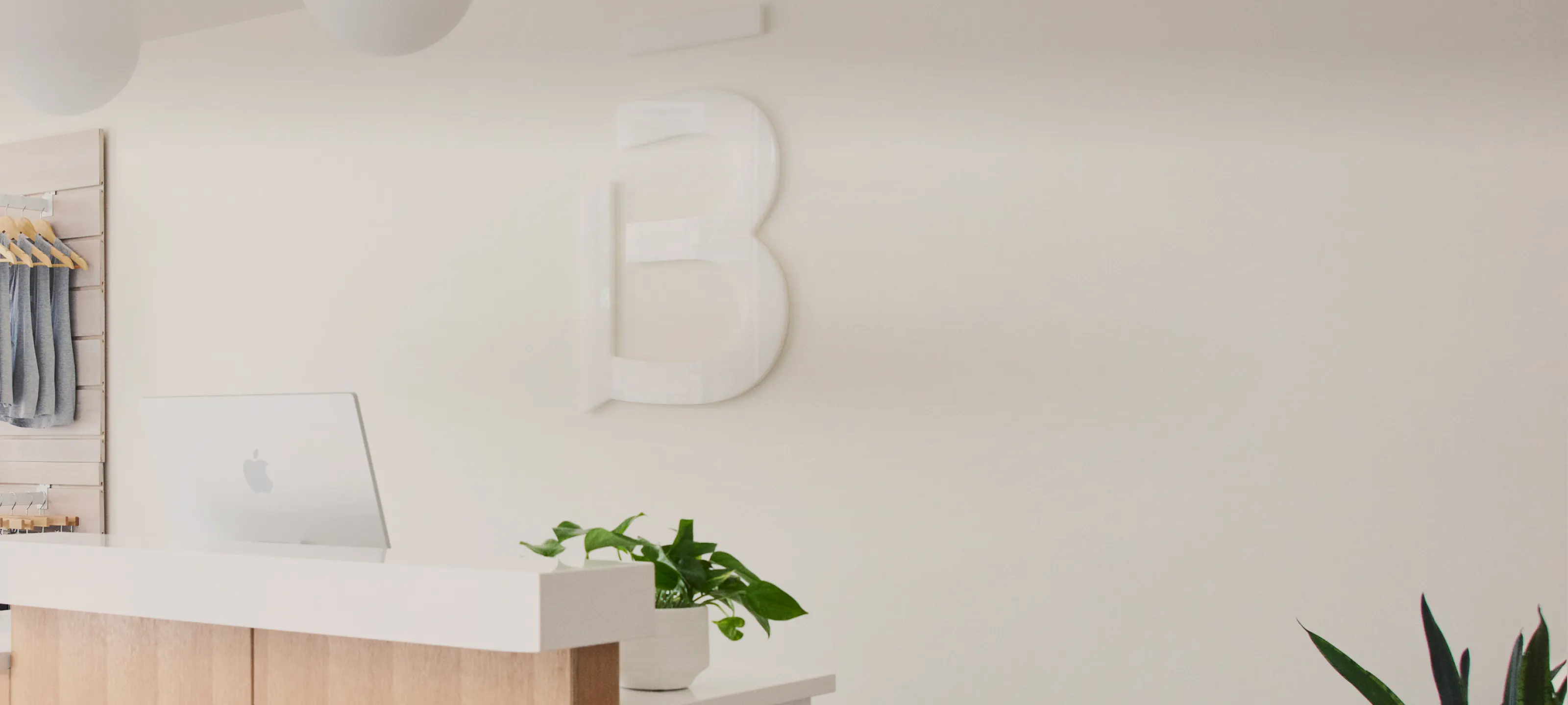 front desk of a barre3 studio with a B logo on the back wall